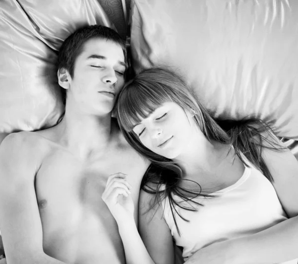Jovem casal dormindo em uma cama — Fotografia de Stock