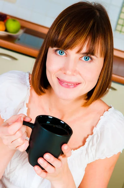 若い女性が、彼女の家でコーヒーのカップを楽しむ. — ストック写真