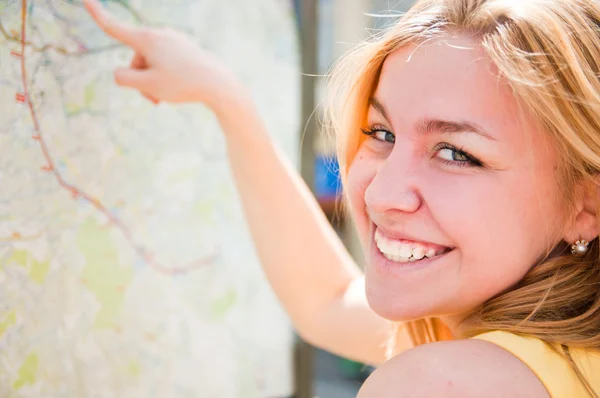Junge Frau schaut auf einer Landkarte — Stockfoto