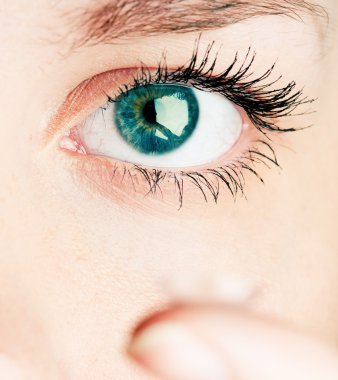 Close up of inserting a contact lens in female eye clipart