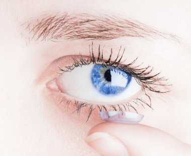 Close up of inserting a contact lens in female eye clipart