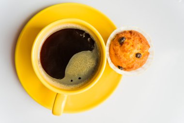 Sarı bir fincan ve kek kahve