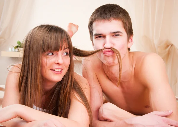 Heureux jeune couple. Garçon fait une moustache de ses cheveux — Photo