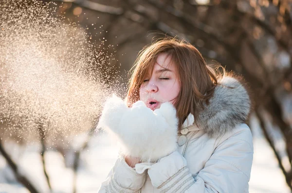 Mooie vrouw waait in de sneeuw — Stockfoto