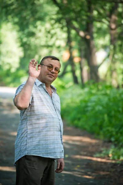 brunette man greeting somebody with hand.