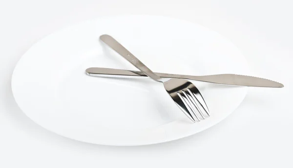 Nůž a vidličku na bílé desce — Stock fotografie