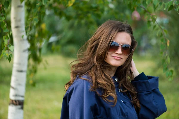 Frau in blauer Jacke im grünen Sommerpark — Stockfoto