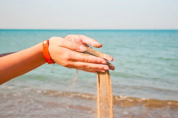 Csökkenő homok nő kezében tenger felett — Stock Fotó
