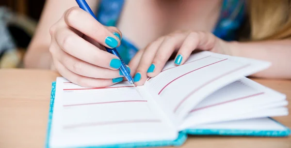 Mano de mujer joven tomando notas — Foto de Stock