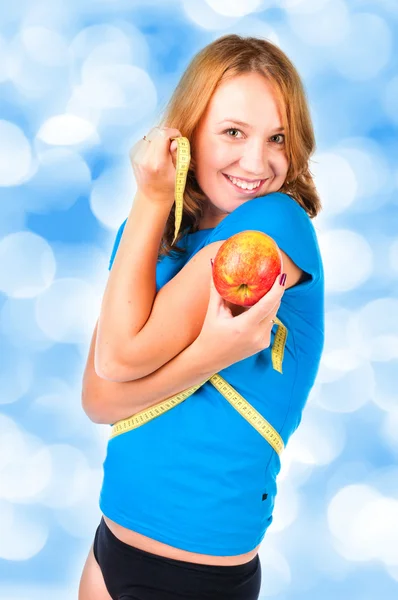 Portrait of a young sport woman holding apple and measuring tape — Stock Photo, Image