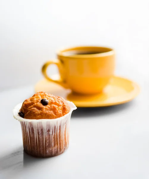 Caffè in una tazza gialla e un muffin — Foto Stock