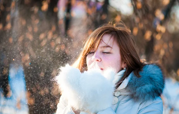 Hermosa mujer soplando en la nieve — Foto de Stock