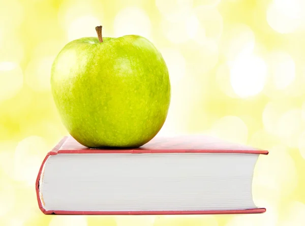 A green apple on a book — Stock Photo, Image