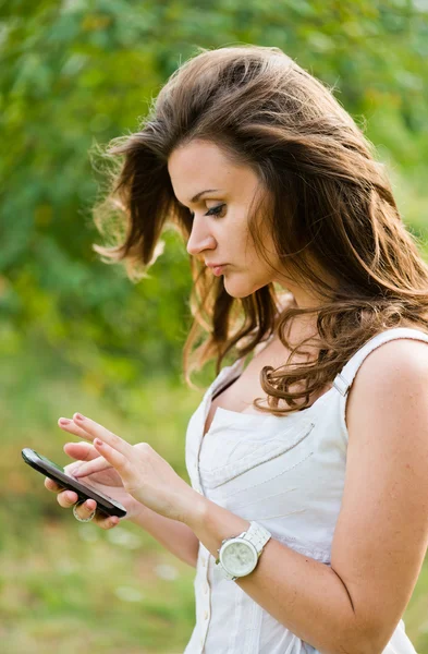 Utomhus porträtt av ung kvinna med telefonen — Stockfoto