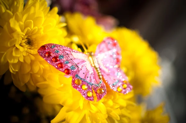 Borboleta decoração brinquedo sobre flores — Fotografia de Stock