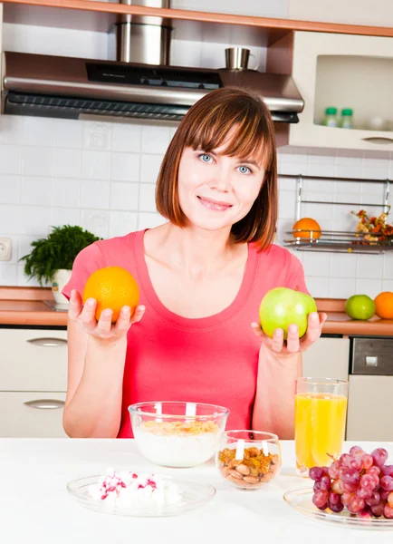 Hermosa mujer sosteniendo una manzana y naranja — Foto de Stock