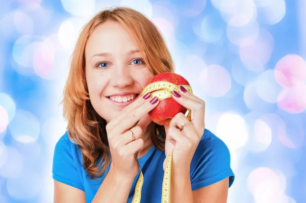 Portrait of a young sport woman holding apple and measuring tape — Stock Photo, Image