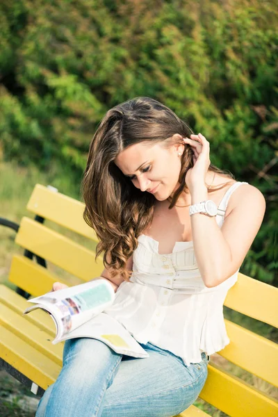 Frau las im Park eine Zeitschrift — Stockfoto