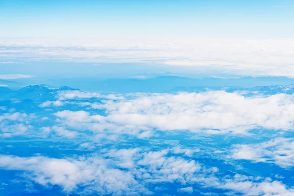 Mit Wolken über die Berge fliegen — Stockfoto