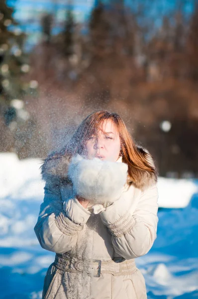雪の中で吹いている美しい女性 — ストック写真