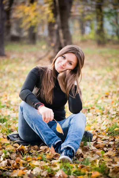 Beautiful thoughtful girl in autumn park — Stock Photo, Image