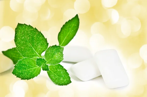 Chewing gym and fresh leaves of mint — Stock Photo, Image