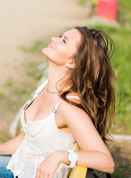 Bela mulher relaxar no banco no parque — Fotografia de Stock