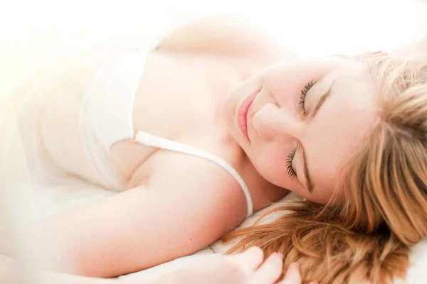 Sexy blond žena spát na posteli ve spodním prádle — Stock fotografie