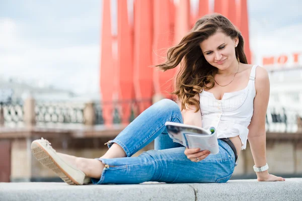 Outdoor portrait of young woman with fashion magazine — Stock Photo, Image