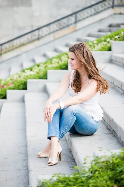 Portrait of a beautiful european woman sitting om steps — Stock Photo, Image