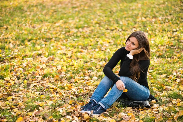 Beautiful thoughtful girl in autumn park — Stock Photo, Image