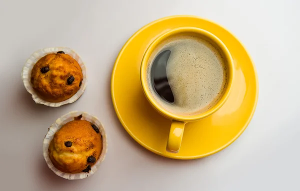 Café en una taza amarilla y magdalenas —  Fotos de Stock