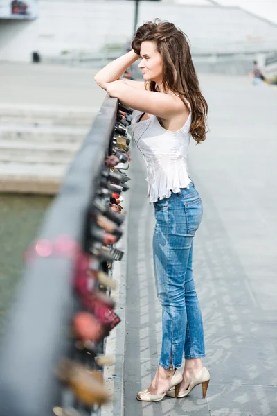 Beautiful thoughtful woman near fence with wedding locks — Stock Photo, Image