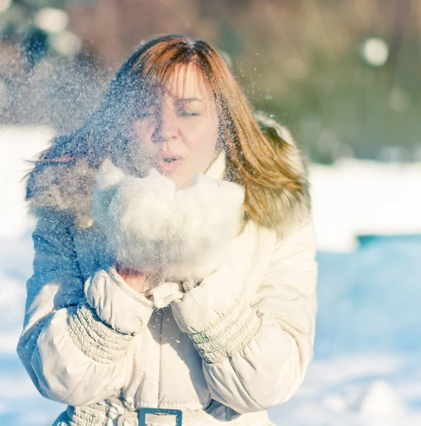 Mulher bonita soprando na neve — Fotografia de Stock