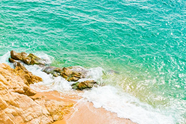 Les vagues se brisent sur une pierre avec la lumière du jour — Photo