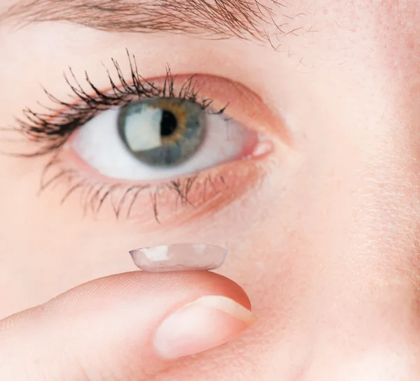 Primer plano de la inserción de una lente de contacto en el ojo femenino — Foto de Stock
