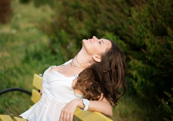 Bella donna rilassarsi sulla panchina nel parco — Foto Stock