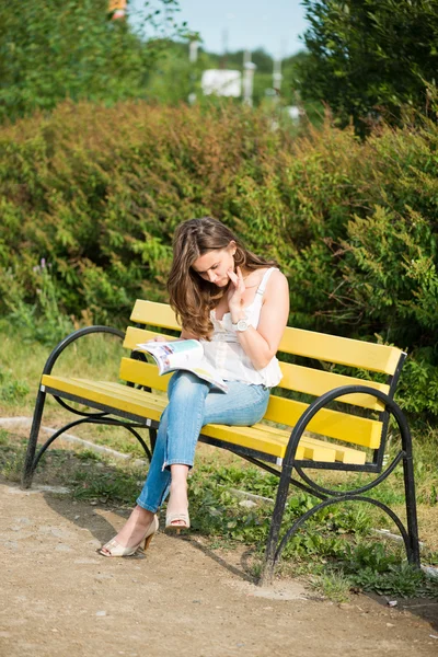 Una donna legge una rivista nel parco — Foto Stock