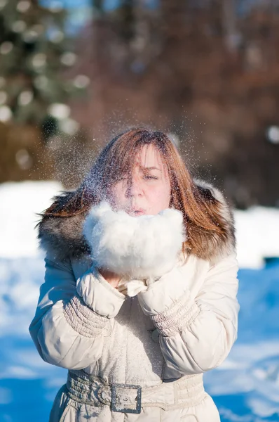 Mulher bonita soprando na neve — Fotografia de Stock