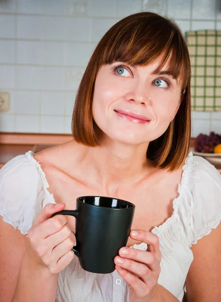 Jonge vrouw, genieten van een kopje koffie in haar huis. — Stockfoto