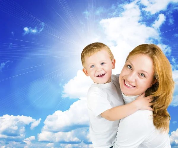 女性と青い空を背景に小さな男の子 — ストック写真