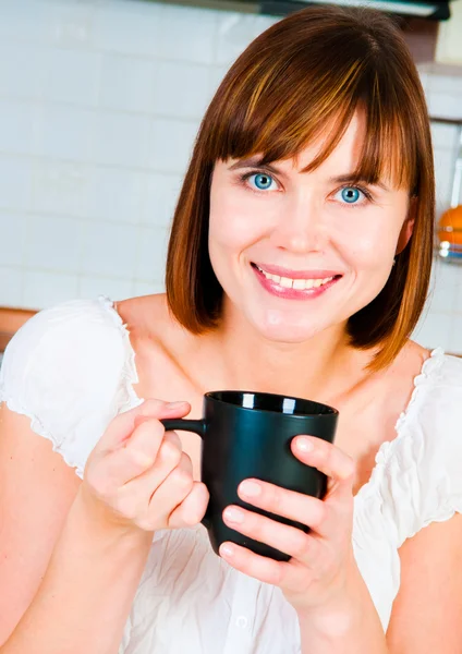 Jonge vrouw, genieten van een kopje koffie in haar huis. — Stockfoto