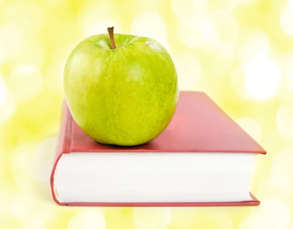 Uma maçã verde em um livro — Fotografia de Stock