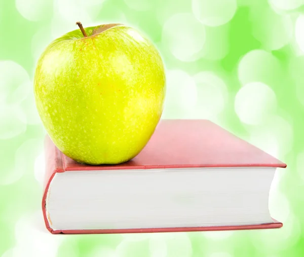 A green apple on a book — Stock Photo, Image