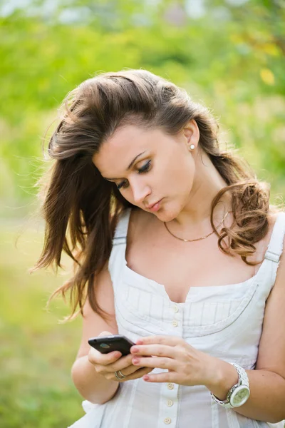 Utomhus porträtt av ung kvinna med telefonen — Stockfoto