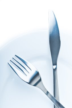 bıçak ve çatal beyaz plaka üzerinde