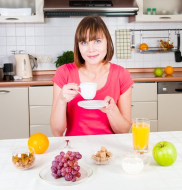 Genç bayan bir fincan kahvenin keyfini çıkarıyor.
