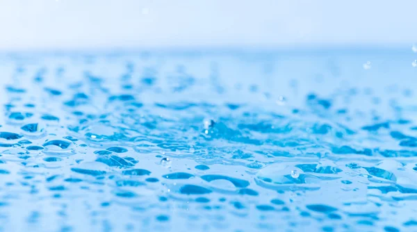 Splash de água na superfície azul — Fotografia de Stock