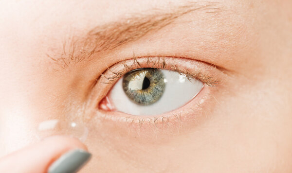 Close up of inserting a contact lens in female eye