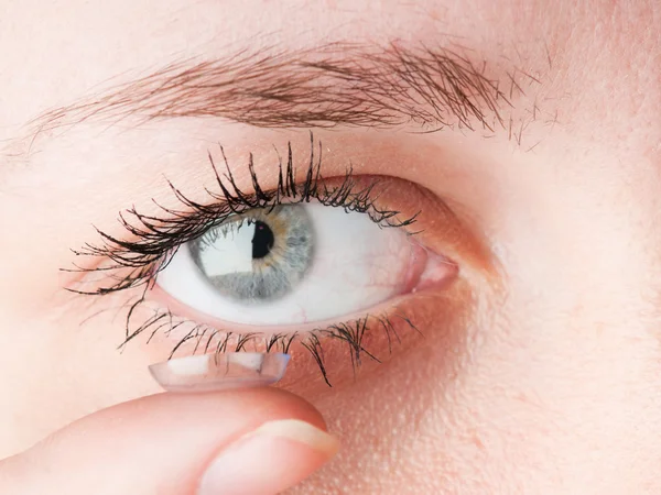 Fechar a inserção de uma lente de contacto no olho feminino — Fotografia de Stock